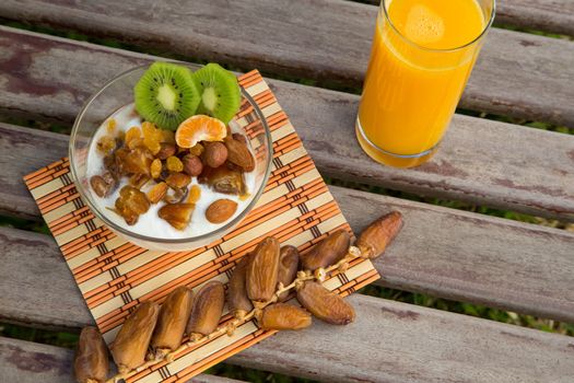 Healthy breakfast - natural yogurt with dried fruits and orange juice