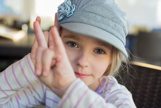 Cute girl showing horn signs with both hands