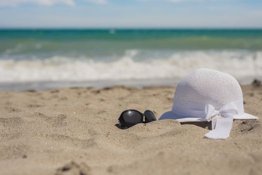 White wicker hat and sunglasses on the beach