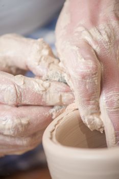 Hands of a potter, creating an earthen jar on the circle