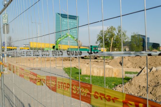 iron fence with red yellow security tape stop the construction site in the city