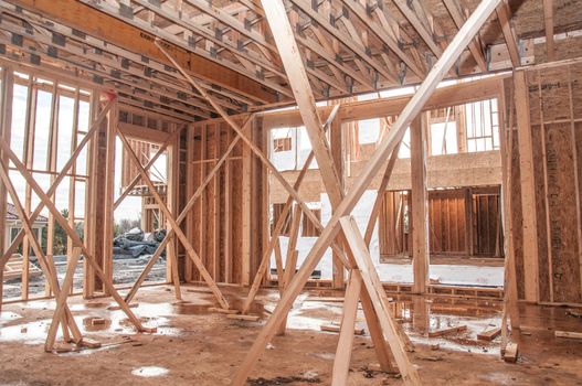 Unfinished house construction frame under rain