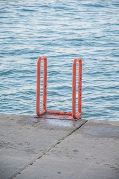 Ladder by concrete water edge at lake