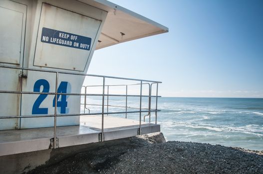 Baywatch lifeguard tower on beach under bright blue sky