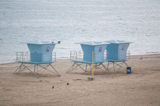 Baywatch lifeguard tower on beach under bright blue sky