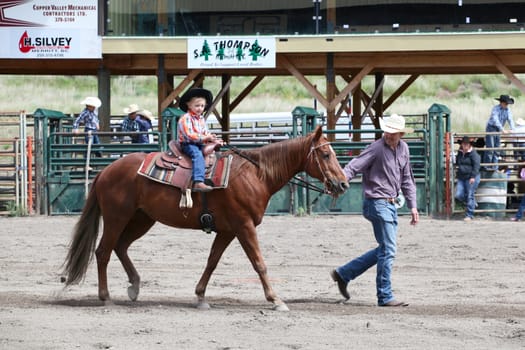 MERRITT, B.c. CANADA - June 14:  Young cowboy and his dad in stake race event at the Little Britches Rodeo June 14, 2014 in Merritt British Columbia, Canada