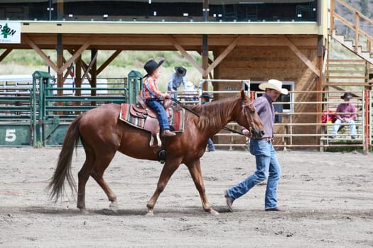 MERRITT, B.c. CANADA - June 14:  Young cowboy and his dad in stake race event at the Little Britches Rodeo June 14, 2014 in Merritt British Columbia, Canada