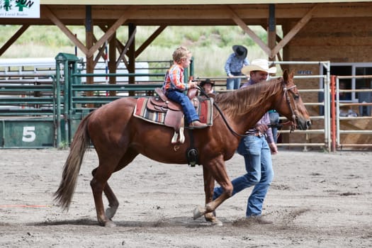 MERRITT, B.c. CANADA - June 14:  Young cowboy and his dad in stake race event at the Little Britches Rodeo June 14, 2014 in Merritt British Columbia, Canada