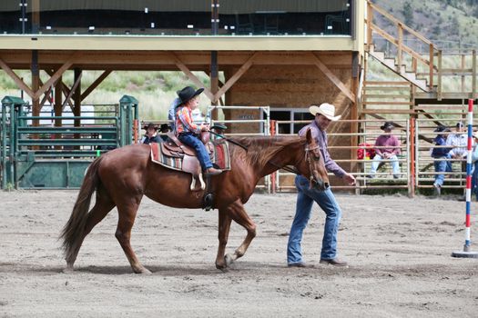 MERRITT, B.c. CANADA - June 14:  Young cowboy and his dad in stake race event at the Little Britches Rodeo June 14, 2014 in Merritt British Columbia, Canada