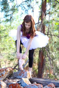 Beautiful girl wearing a white tutu tying her shoe