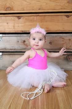 Baby ballerina wearing a white tutu and pink bodysuit 