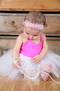 Baby ballerina wearing a white tutu and pink bodysuit 