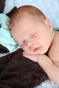 Newborn baby boy wrapped in warm blue blankets