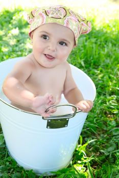 Beautiful baby girl having a bath outdoors