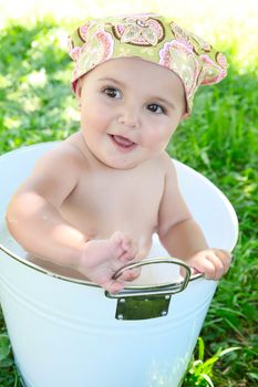 Beautiful baby girl having a bath outdoors