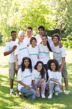 Group portrait of confident multiethnic volunteers together in park