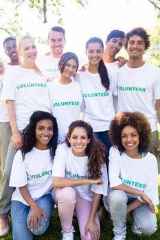 Group portrait of happy multiethnic volunteers together in park