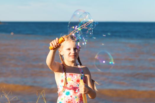 gilrl with soap bubbles on the seashore