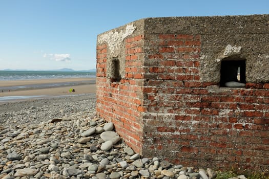 A red brick constructed defence bunker from the second world war looking out to sea.