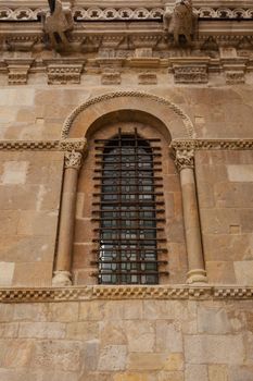 Excellent piece of romanesque art window with fine forged protection in the side wall of the San Isidoro collegiate church in Leon ,Spain