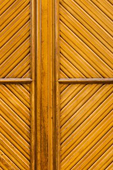 Fine rhomboid pattern in a door made from wood and yellowish coloured