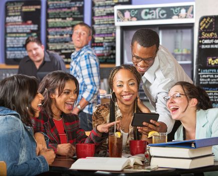 Laughing group of students looking at cell phone