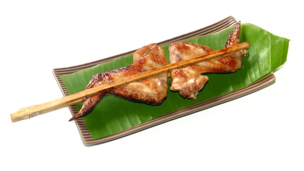 Roasting chicken with bamboo stick in Thai style, Thai food isolated