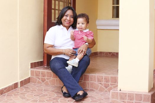 Mother and son outside of their new house. Focus on the baby.