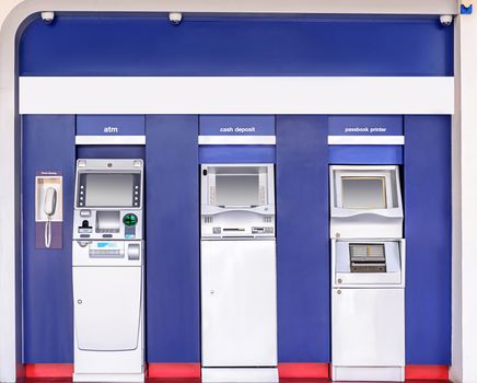 Automatic banking service point on the wall outside building.