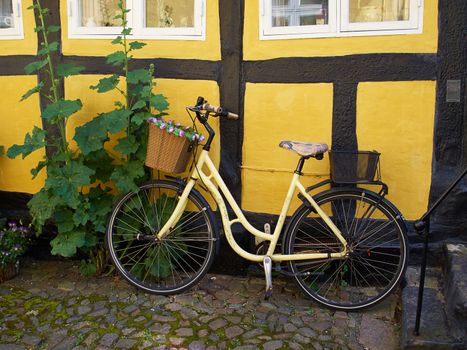 Vintage Classical  Yellow Bicycle in front of an old house Denmark