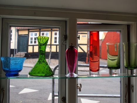 Beautiful decorative colorful glass carafes vase bottles in a window of a shop