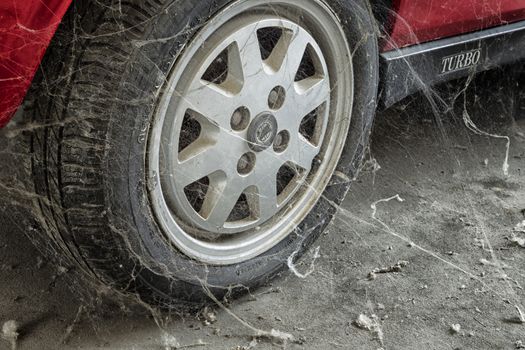 A 80���s car tire among cobwebs and dust 