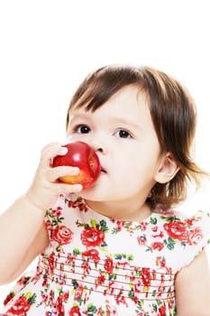 Little girl tasting an apple for the first time