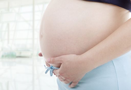 Closeup of pregnant woman at white background