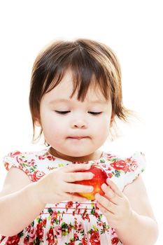 Infant girl looking looking at a fresh red apple