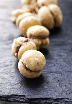 Biscuits "Baci di dama" in a row over black stone