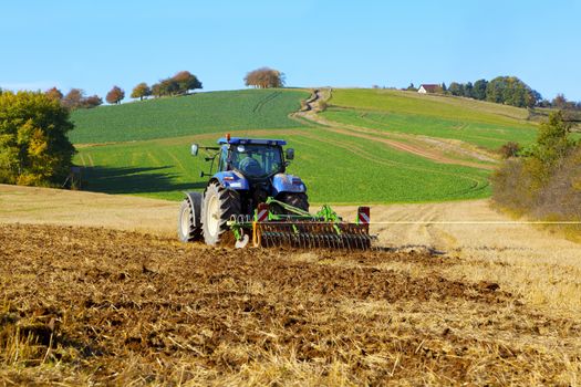 farm tractor on the field working, plowing land