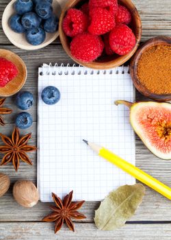 top view of recipe book with ingredients on wooden table