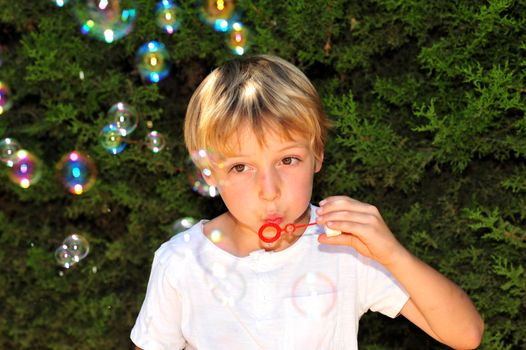 Young boy playing with bubbles in the garden