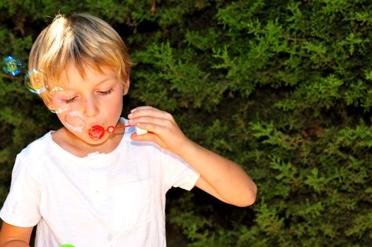 Young boy playing with bubbles in the garden