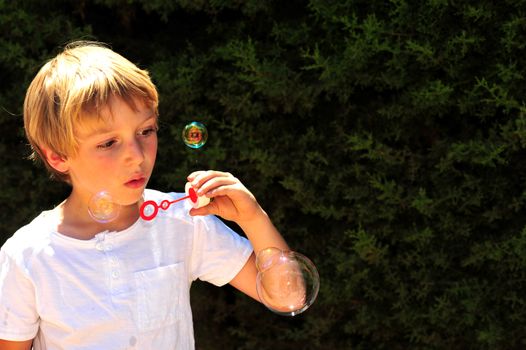 Young boy playing with bubbles in the garden