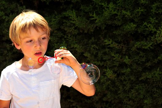 Young boy playing with bubbles in the garden