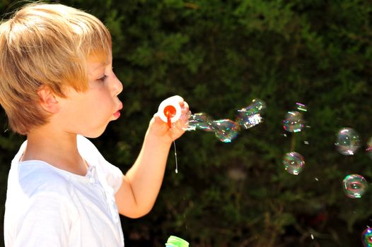 Young boy playing with bubbles in the garden