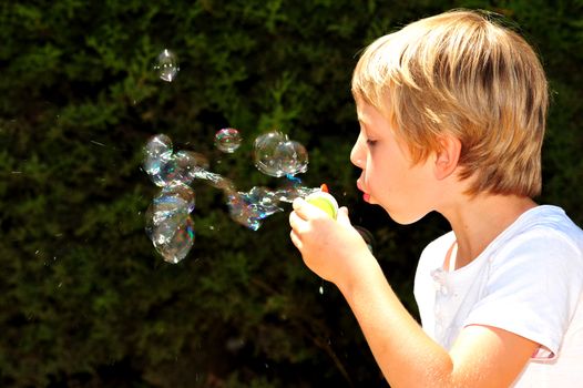 Young boy playing with bubbles in the garden