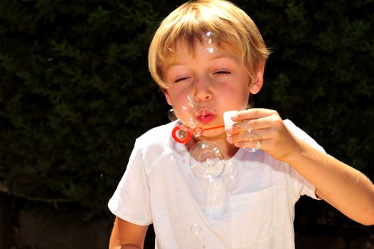 Young boy playing with bubbles in the garden