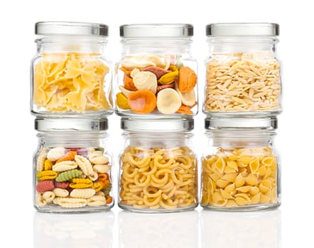 the various raw pasta in a glass jar,  isolated on white background