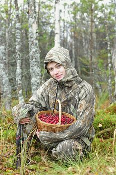 Young woman pick cranberry on a bog. Young woman pick cranberry on a bog.