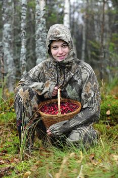 Young woman pick cranberry on a bog. Young woman pick cranberry on a bog.