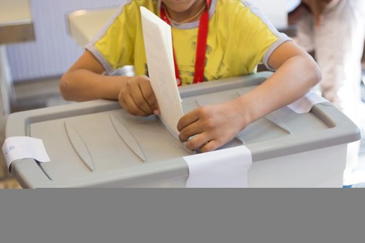 Little boy voting on democratic parliamentary election.