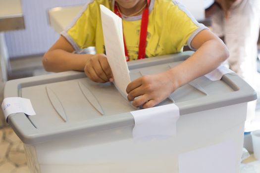 Little boy voting on democratic parliamentary election.